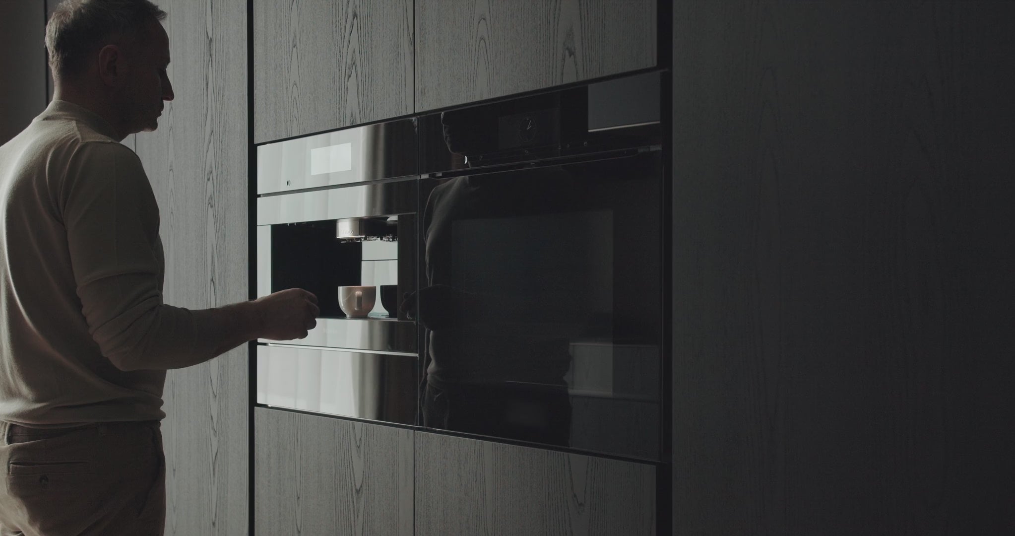 Load video: person using a modern kitchen water machine in a home setting