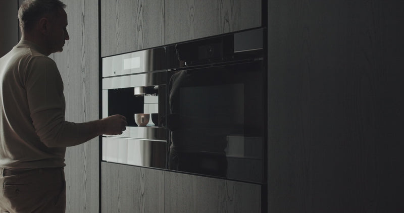 person using a modern kitchen water machine in a home setting